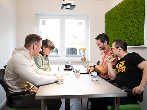 4 Personen an einem Tisch 